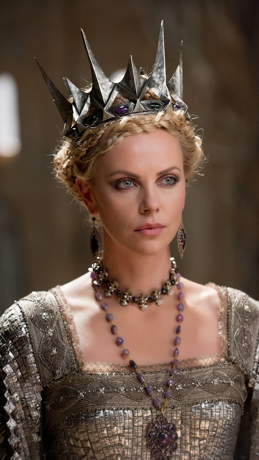 Charlize Theron as the Snow Queen in a spiked silver crown and ornate medieval gown HD phone wallpaper