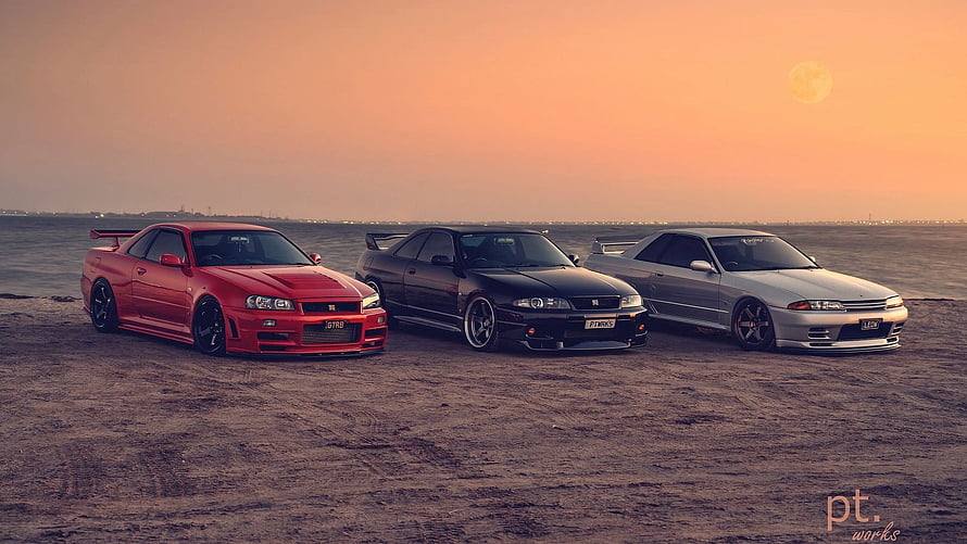 Three Nissan Skyline GT-R R34 coupes parked on a desert plain at sunset HD wallpaper