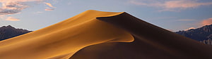 Golden Sand Dune Ridge with Mountain Silhouettes at Sunset HD wallpaper