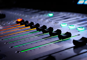 Professional Audio Mixing Console with Glowing Faders and Illuminated Controls in a Recording Studio HD wallpaper