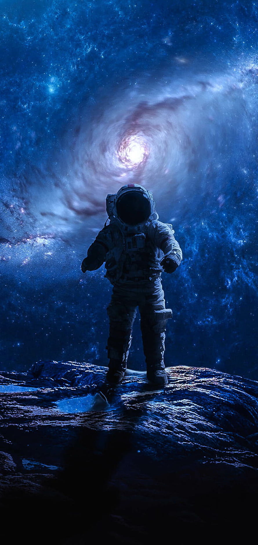 Astronaut Standing on Rocky Terrain Facing a Luminous Cosmic Vortex in Deep Space HD phone wallpaper