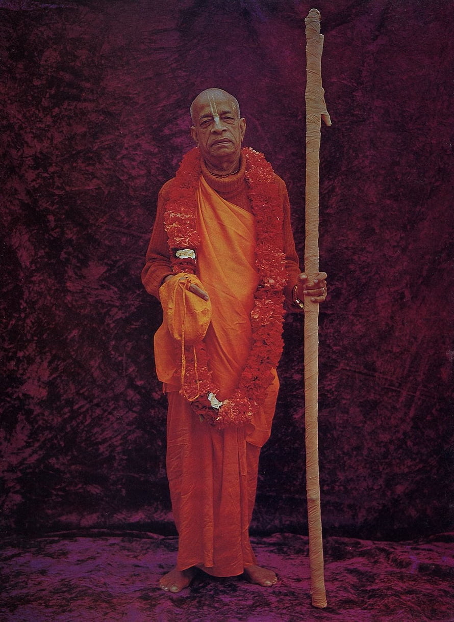 Srila Prabhupada in saffron robes with flower garland and wooden staff HD phone wallpaper