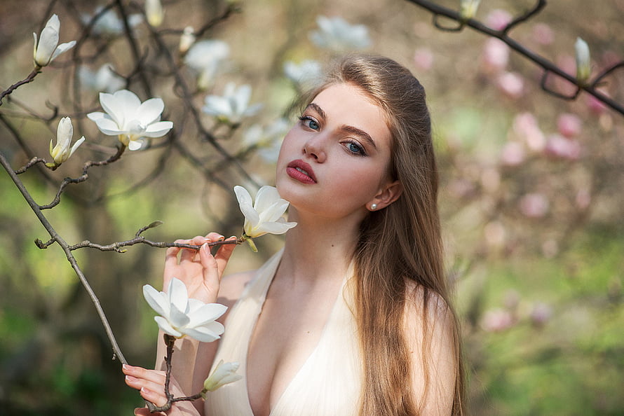 Elegant Woman Portrait Amidst White Magnolia Blossoms in a Spring Garden HD wallpaper