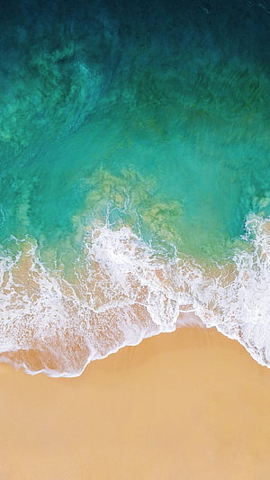 Aerial View of Turquoise Ocean Waves Rolling onto a Golden Sandy Beach HD phone wallpaper