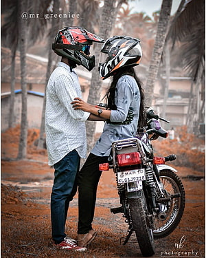 Couple in Motorcycle Helmets Standing Beside a Bike in a Tropical Setting HD phone wallpaper