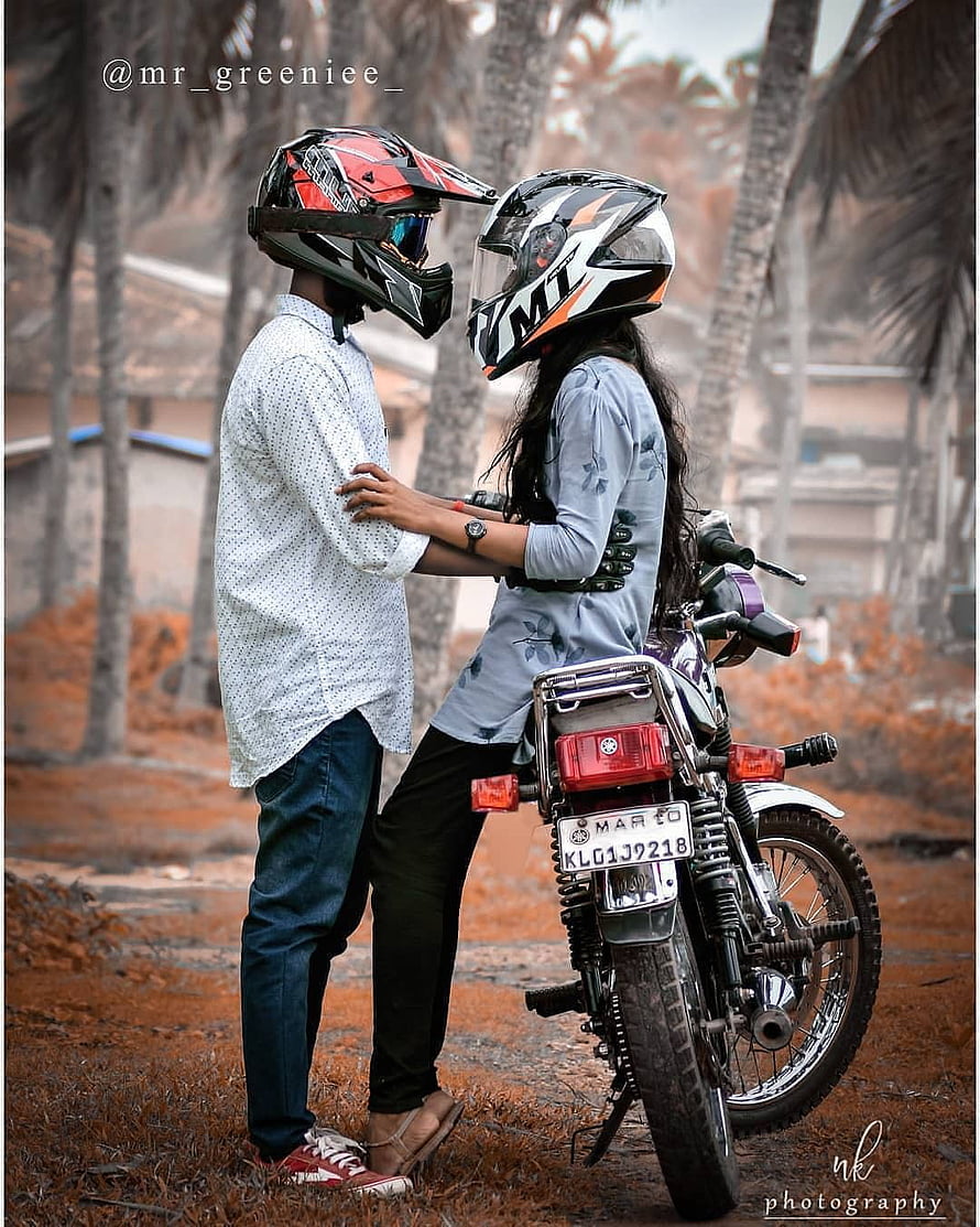 Couple in Motorcycle Helmets Standing Beside a Bike in a Tropical Setting HD phone wallpaper
