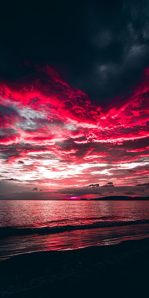 Vibrant Crimson Sunset Over the Ocean with Dramatic Red Clouds and Dark Beach HD phone wallpaper