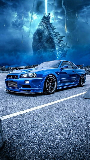 Blue Nissan Skyline R34 GT-T Coupe Parked Before a Giant Godzilla Silhouette Under a Stormy Sky HD phone wallpaper