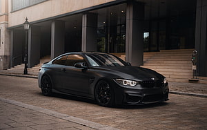 Matte Black BMW M4 F82 Coupe Parked in Front of Modern Architecture HD wallpaper