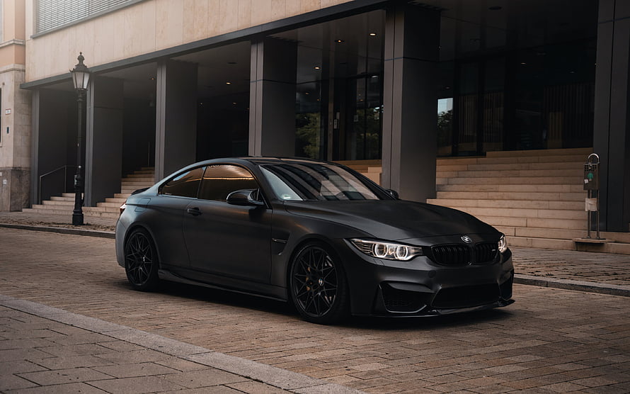 Matte Black BMW M4 F82 Coupe Parked in Front of Modern Architecture HD wallpaper