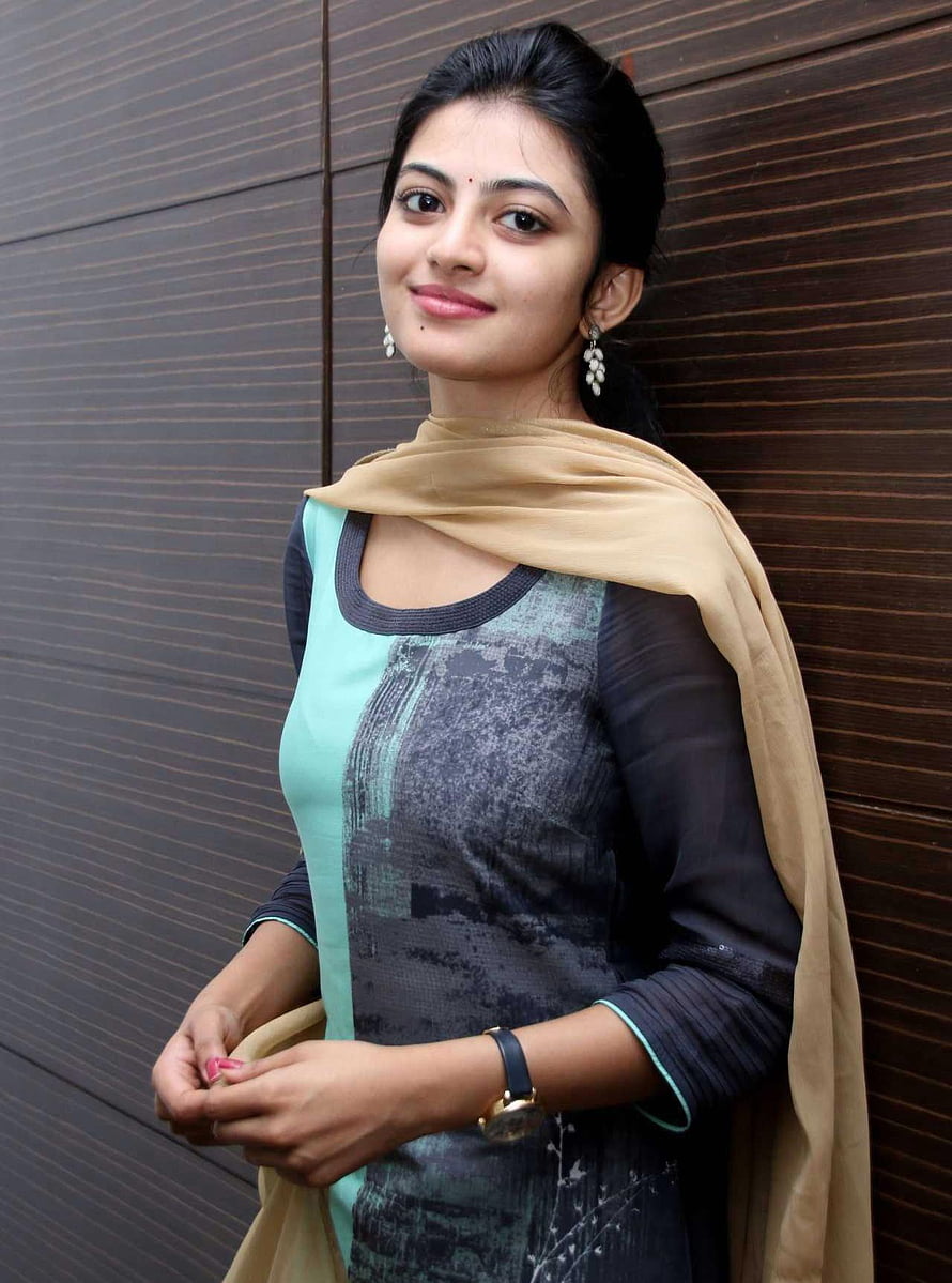 Ananthi in a teal and black printed kurta with a beige dupatta against a dark wood panel wall HD phone wallpaper