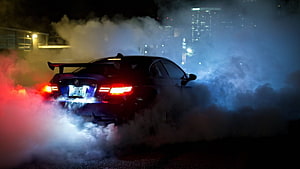 BMW M5 performing a dramatic night drift enveloped in thick tire smoke with glowing taillights HD wallpaper