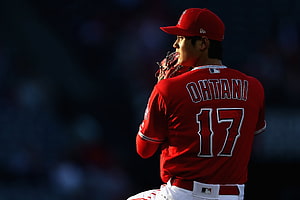 Shohei Ohtani in Los Angeles Angels uniform holding a baseball glove on the field HD wallpaper