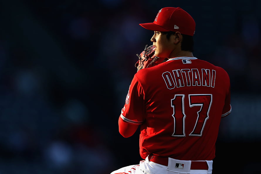 Shohei Ohtani in Los Angeles Angels uniform holding a baseball glove on the field HD wallpaper
