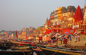 Varanasi Ganga Ghat with Colorful Boats and Temple Architecture at Dusk HD wallpaper
