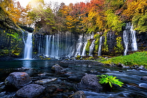 Autumn Waterfall Cascading Over Mossy Rocks Into a Forest Stream HD wallpaper