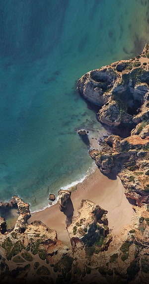 Aerial View of Turquoise Coastal Coves and Rugged Rocky Cliffs HD phone wallpaper