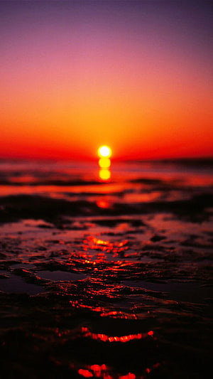 Vibrant Ocean Sunset with Glowing Horizon and Reflective Water Surface HD phone wallpaper