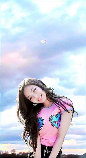 Jennie Blackpink smiling in a pink graphic tee against a pastel sky HD phone wallpaper