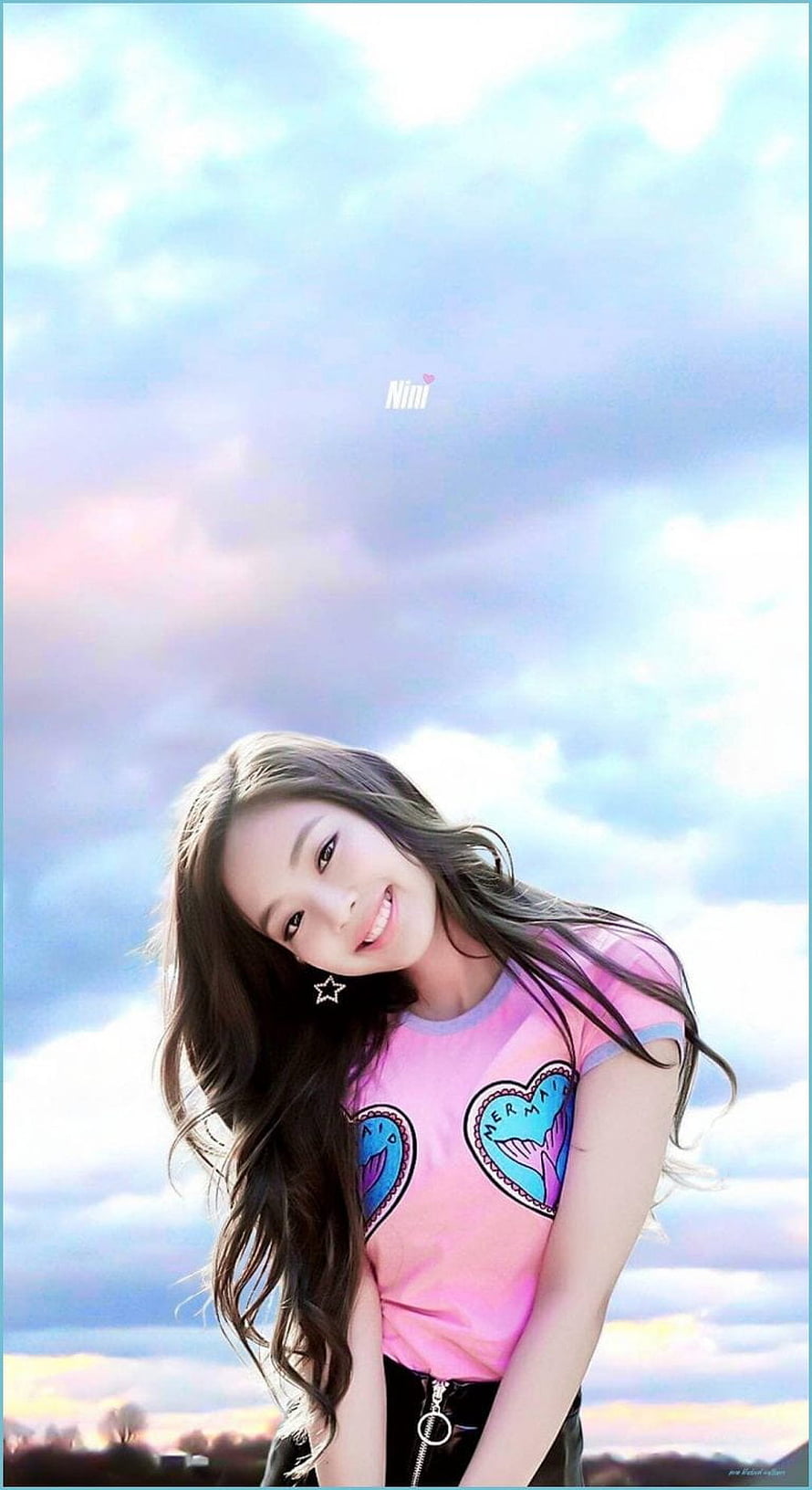 Jennie Blackpink smiling in a pink graphic tee against a pastel sky HD phone wallpaper