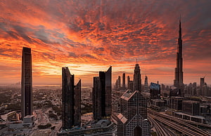 Dubai Skyline at Sunset with Burj Khalifa and Dramatic Orange Clouds HD wallpaper