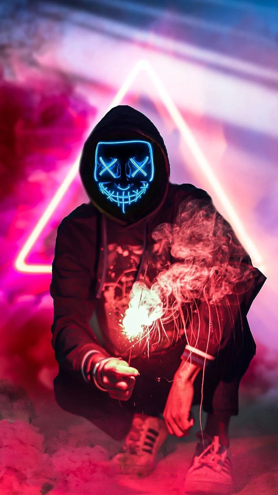Person in glowing blue LED skull mask holding sparkler against neon triangle backdrop HD phone wallpaper