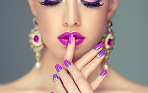 Close-up beauty portrait of a woman with vibrant purple lipstick and matching manicured nails HD wallpaper