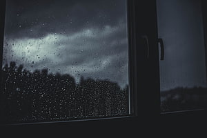 Moody Rainy Day View Through a Window with Dark Stormy Sky and Blurred Trees HD wallpaper
