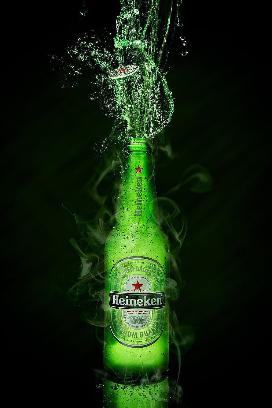 Heineken Lager Beer Bottle with Dramatic Green Splash and Smoke Effect on Black Background HD phone wallpaper