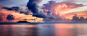 Dramatic Sunset Over Calm Ocean with Silhouetted Island and Vibrant Clouds HD wallpaper