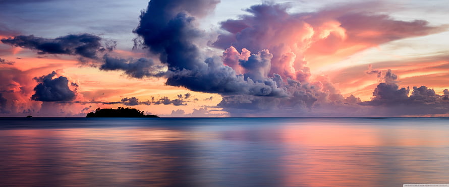 Dramatic Sunset Over Calm Ocean with Silhouetted Island and Vibrant Clouds HD wallpaper