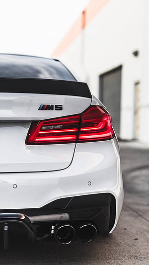 Rear View of White BMW M5 Sedan with Carbon Fiber Spoiler and Quad Exhaust HD phone wallpaper