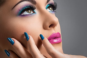 Close-up beauty portrait with vibrant teal eyeshadow, pink lips, and blue manicured nails HD wallpaper