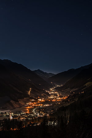Illuminated Alpine Valley Village Under a Starry Night Sky HD phone wallpaper