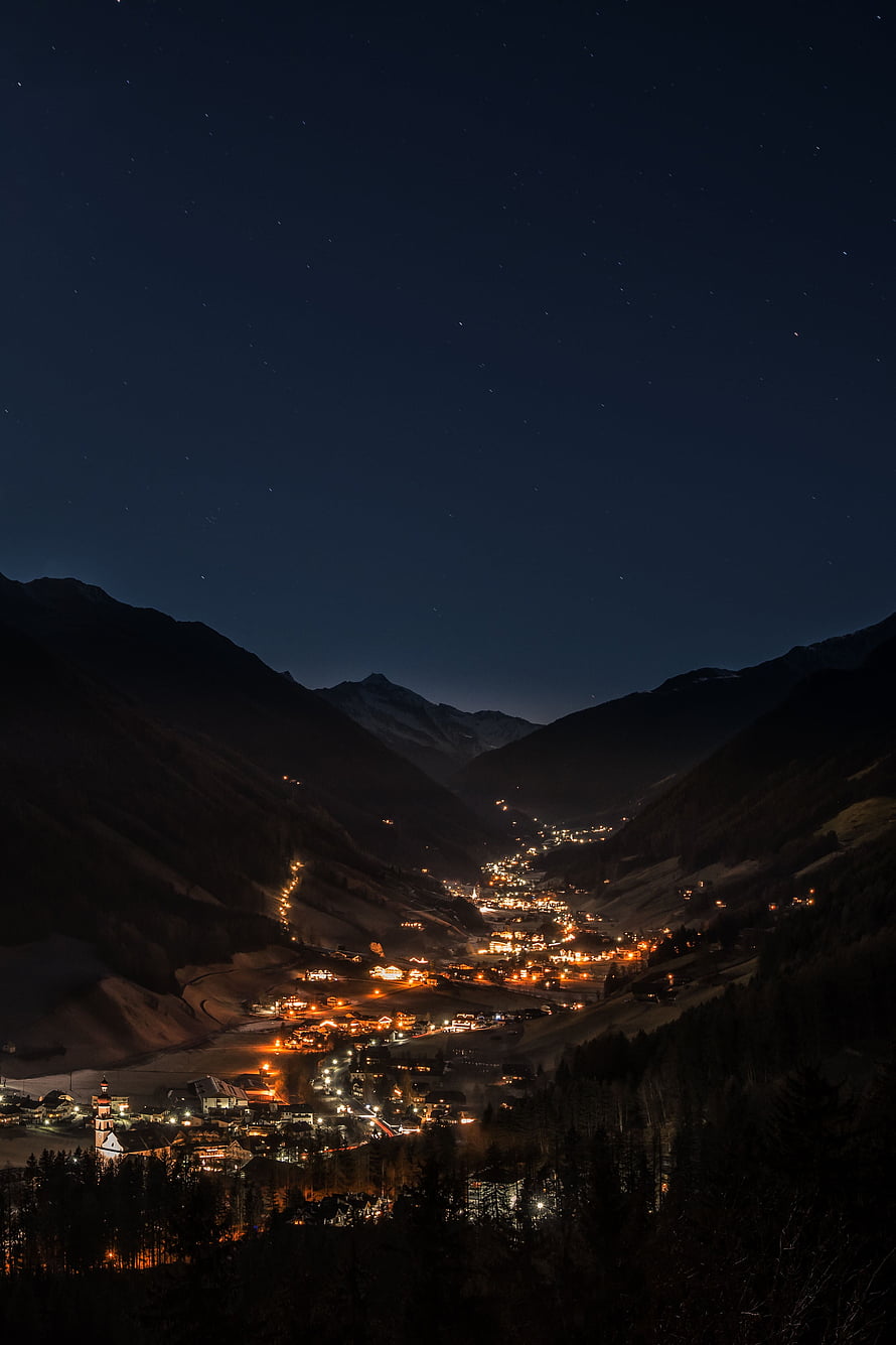 Illuminated Alpine Valley Village Under a Starry Night Sky HD phone wallpaper