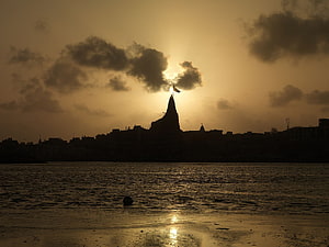 Dwarkadhish Temple Silhouette at Sunset Over the River in Dwarka HD wallpaper