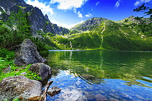 Tatras Mountain Lake Reflection with Rocky Shoreline and Lush Green Slopes HD wallpaper
