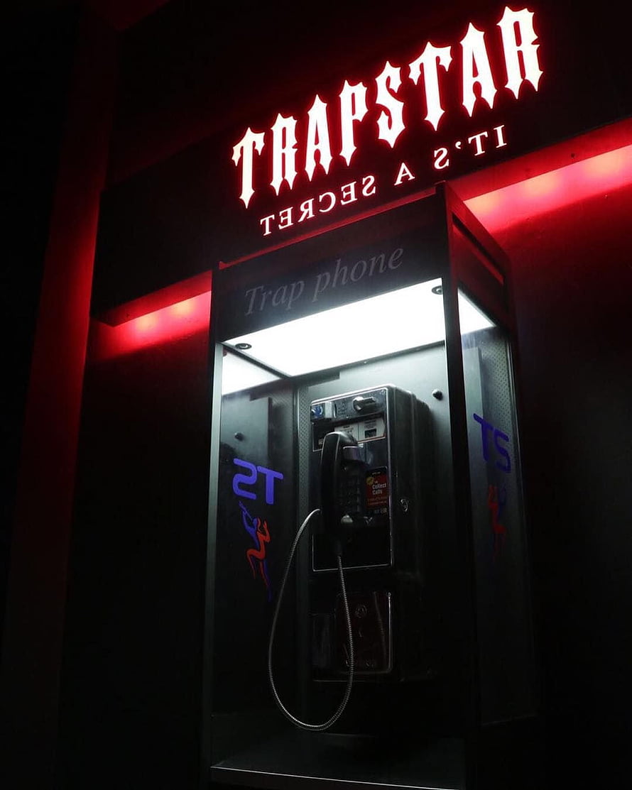 Trapstar It's A Secret Neon Sign Above a Rugged Public Payphone Booth HD phone wallpaper