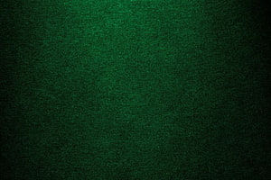 Deep Emerald Green Textured Surface with Subtle Vignette and Grainy Fabric Detail HD wallpaper