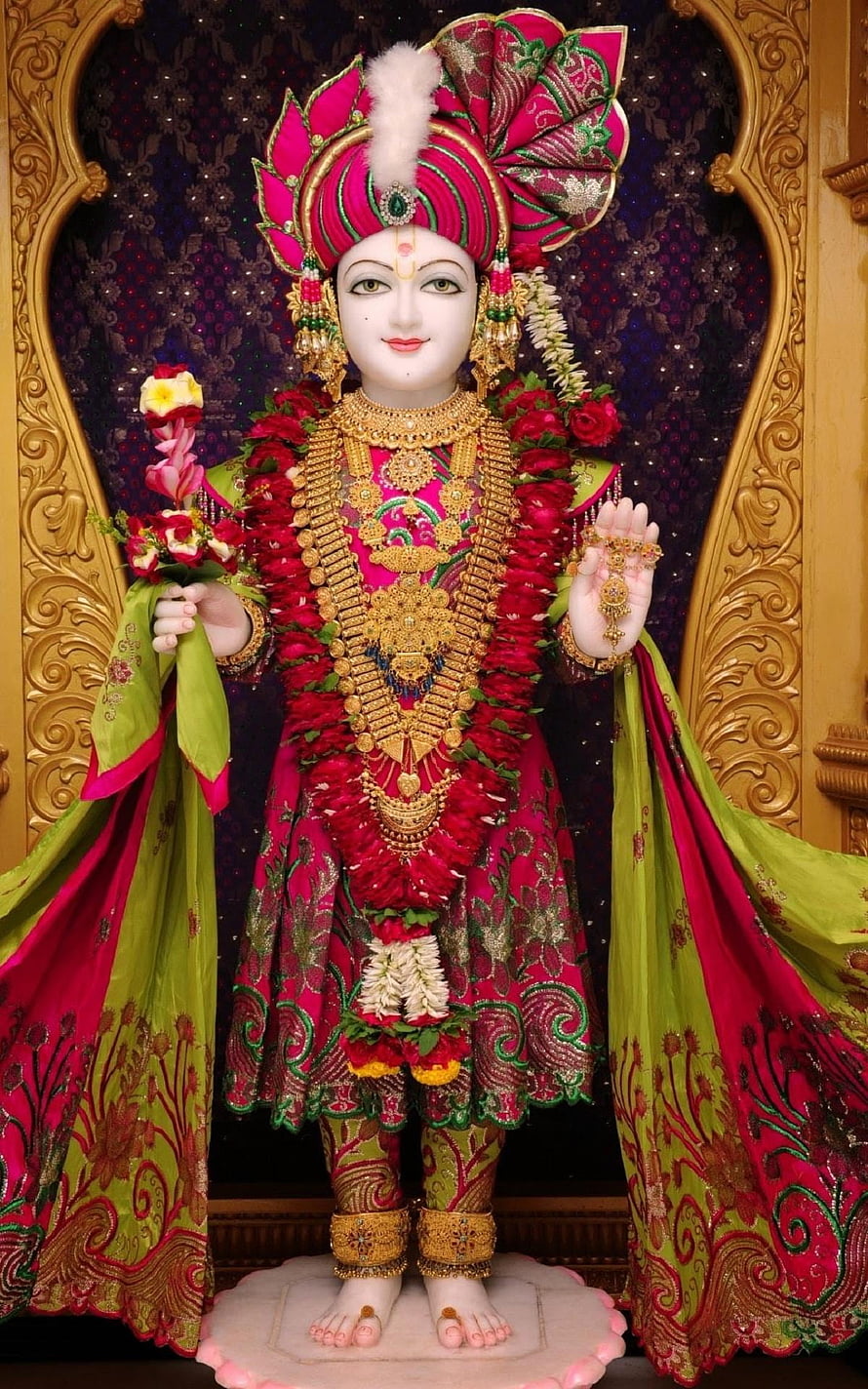 Ornate Swaminarayan Deity Statue Adorned in Vibrant Pink and Green Silk Garments HD phone wallpaper