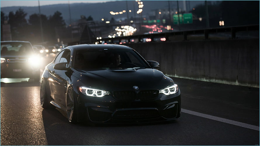 Black BMW M4 Coupe Driving on Highway at Dusk with LED Headlights HD wallpaper
