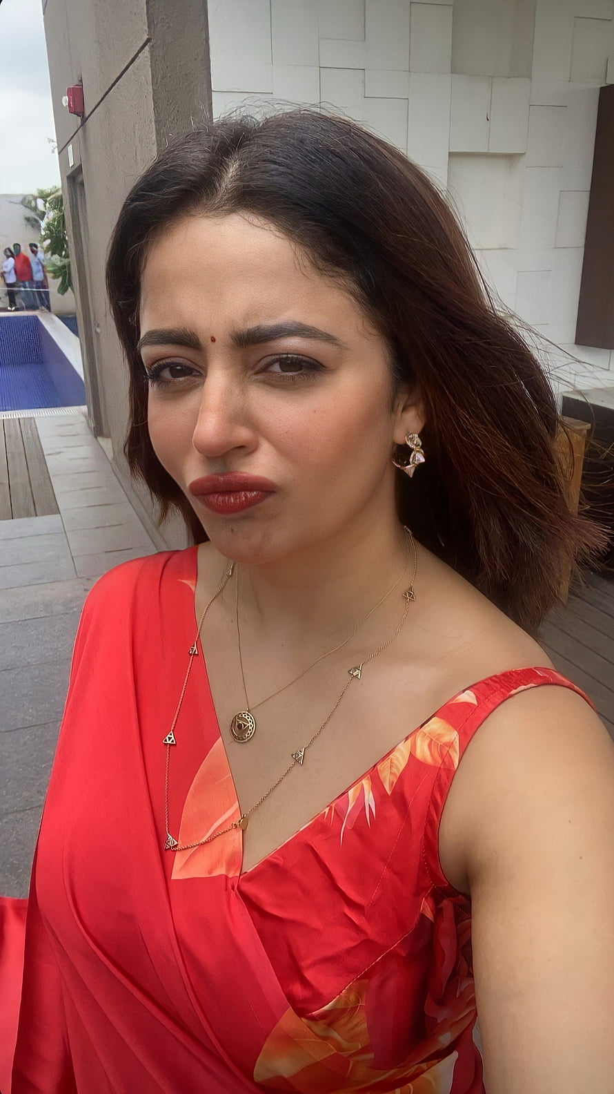 Neha Pendse in a Red Floral Dress with Gold Jewelry and a Playful Expression HD phone wallpaper