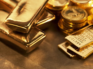 Stacked Gold Bars and Coins on a Dark Surface for Wealth and Prosperity HD wallpaper