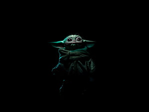 Baby Yoda from The Mandalorian in a dark moody portrait with glowing green skin and large expressive eyes HD wallpaper