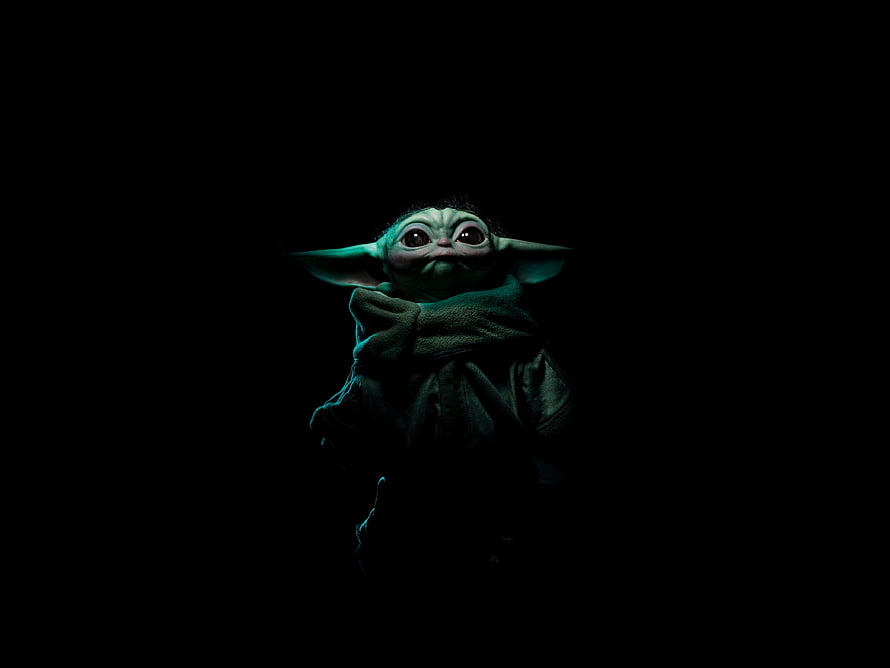 Baby Yoda from The Mandalorian in a dark moody portrait with glowing green skin and large expressive eyes HD wallpaper