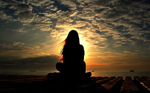 Silhouette of a woman sitting on a wooden pier at sunset with a dramatic cloudy sky, Alone Sad : Alone Sad Girl, Lonely Girl HD wallpaper