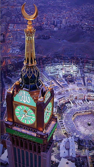 Aerial View of Makkah Clock Tower and Kaaba at Dusk with Golden Crescent Spire HD phone wallpaper