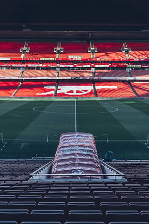 Emirates Stadium Interior View with Arsenal Crest Displayed in Red Seating HD phone wallpaper