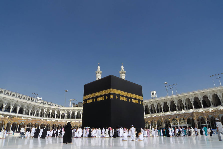 The Kaaba in Mecca with Pilgrims Performing Tawaf Under a Clear Blue Sky HD wallpaper