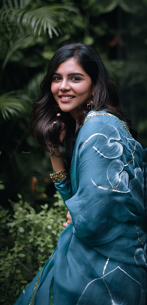 Kalyani Priyadarshan in Teal Embroidered Traditional Attire Amidst Lush Greenery HD phone wallpaper